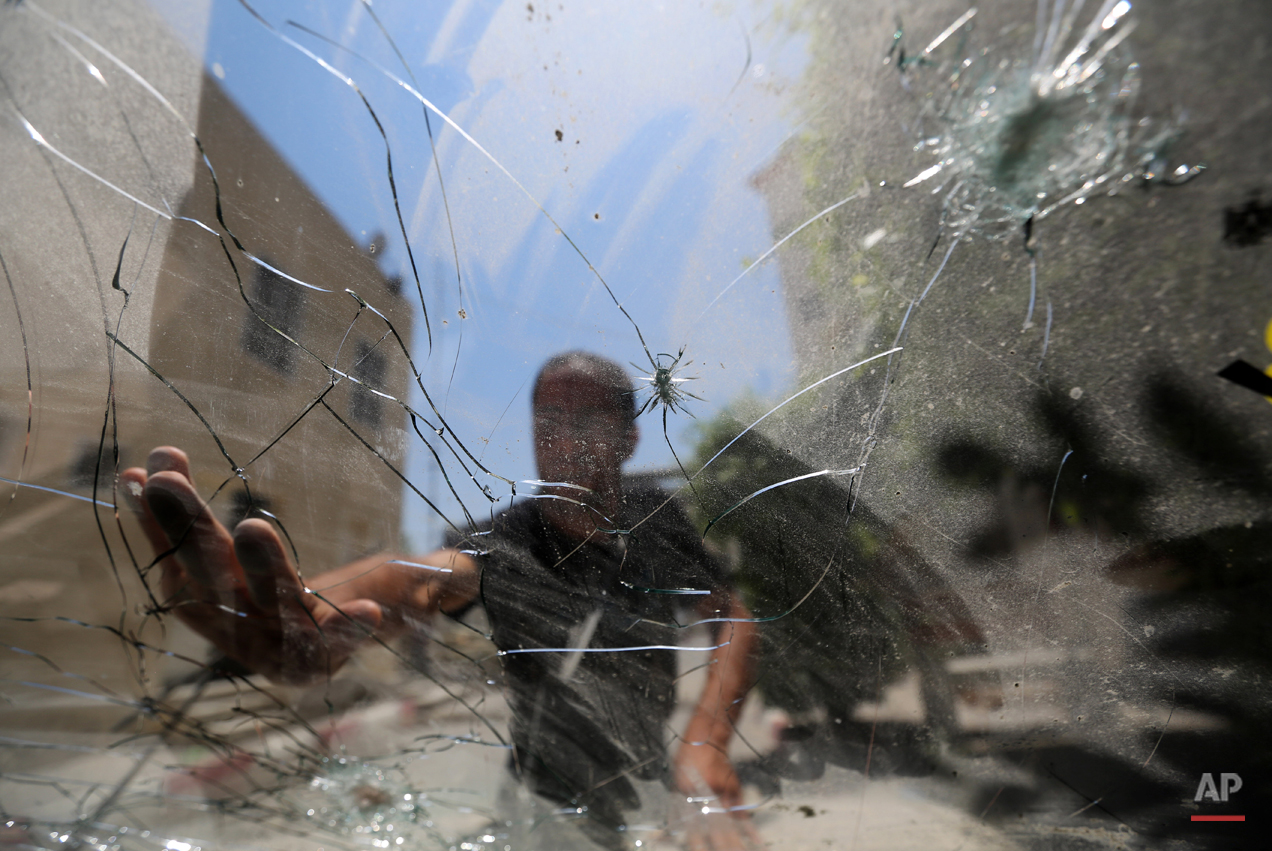  Palestinians check the damage at the Aqsa martyrs hospital which was hit by an Israeli strike Monday, in Deir al-Balah, central Gaza Strip, Wednesday, July 23, 2014. Israeli troops battled Hamas militants on Wednesday near a southern Gaza Strip town