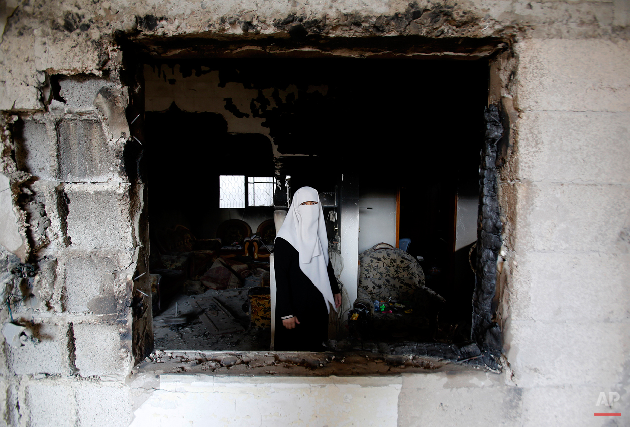  A Palestinian woman stands in the rubble of her destroyed home in Gaza City's Shijaiyah neighborhood, Monday, Aug. 11, 2014. An Egyptian-brokered cease-fire halting the Gaza war held into Monday morning, allowing Palestinians to leave homes and shel