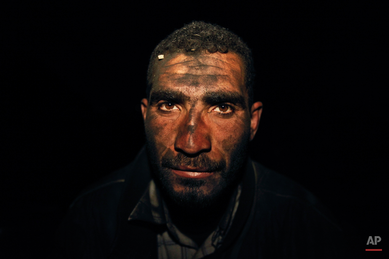  In this Wednesday March 27, 2013 photo, Palestinian worker Hamuda Mahdi, who oversees production of coal at night, poses for a photograph at one of the few local charcoal manufacturing shops, east of Gaza City. In adapting to years of border blockad