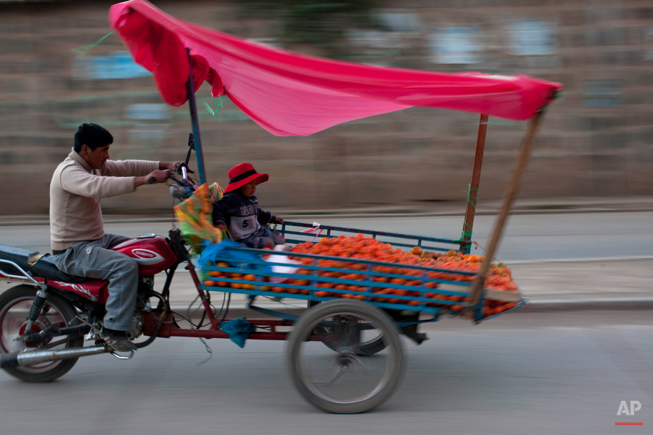  A man rides a motorcycle attached to a makeshift container that serves as a vendors' stand when stationary, in Huancavelica, Peru, Tuesday, Aug. 20, 2013. (AP Photo/Rodrigo Abd) 