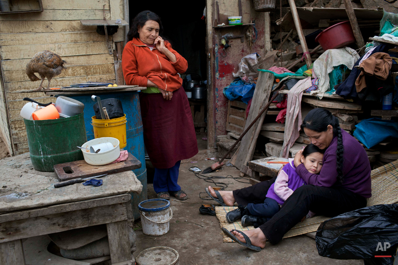 Maria Esperanza Vargas Lopez, 28, embraces her daughter Saomi, 5, as they gather in their house with her mother Felicita Lopez in the Vista Alegre neighborhood in Lima, Peru, Thursday, July 25, 2013. (AP Photo/Rodrigo Abd)