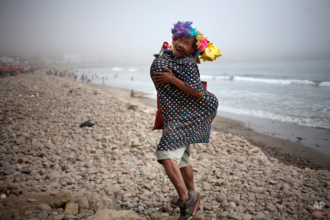 Eduardo, a street vendor who sells snacks to beach goers, strikes a pose on the shore of La Herradura beach in Lima, Peru, Saturday, March 15, 2014. Some street vendors in Lima will dress to achieve a voluptuous body type using balloons and banter with potential customers to attract attention, in hopes of increasing their sales. (AP Photo/Rodrigo Abd)