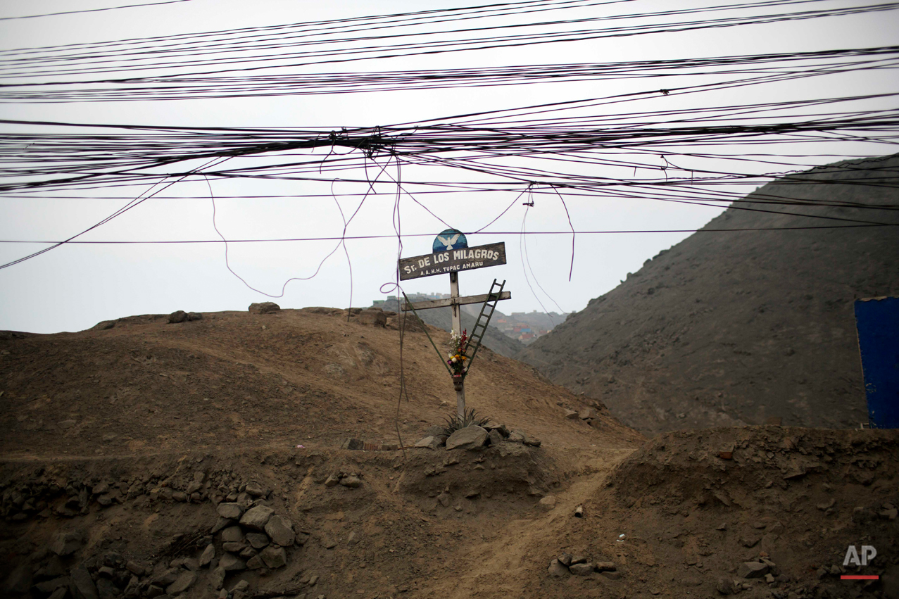 A cross paying reverence to the "The Lord of Miracles," one Peru's most popular religious image, is seen at the entrance of the shanty town Tupac Amaru in Lima, Peru, Tuesday, Aug. 19, 2014. (AP Photo/Rodrigo Abd)