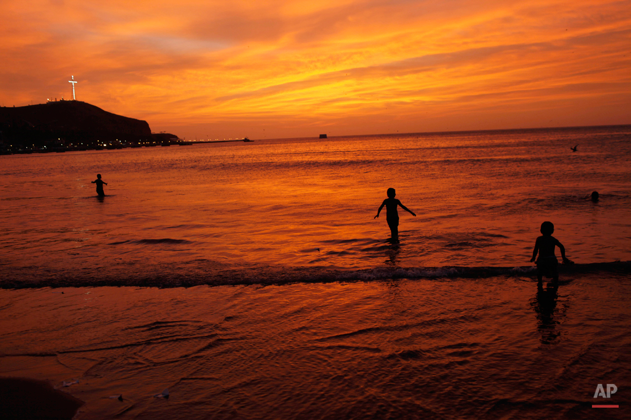Children play on the shore of the Pacific Ocean in Lima, Peru, Sunday, Jan. 13, 2013. (AP Photo/Rodrigo Abd)