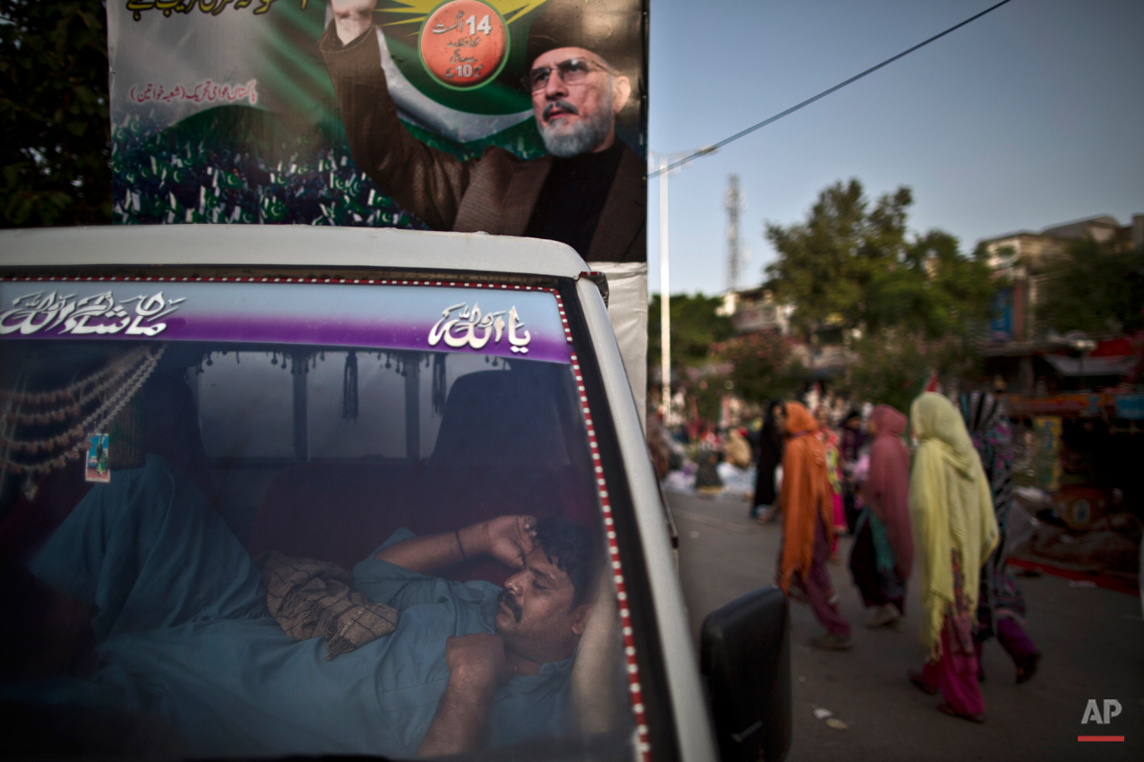 A supporter of anti-government cleric Tahir-ul-Qadri, sleeps inside a vehicle decorated with a big poster showing Tahir-ul-Qadri, during a protest, in Islamabad, Pakistan, Sunday, Aug. 17, 2014. Qadri led massive rallies Saturday in Pakistanís capital, demanding Prime Minister Nawaz Sharif step down over alleged fraud in last yearís election in front of thousands of protesters. (AP Photo/Muhammed Muheisen)