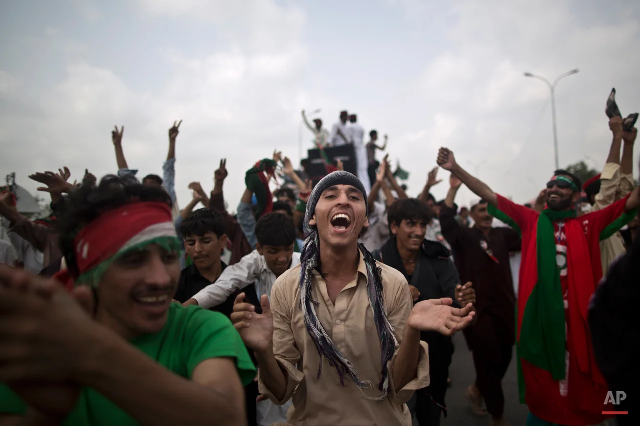 Supporters of Pakistan's cricketer-turned-politician Imran Khan, chant slogans, while waiting for other supporters marching to Islamabad from Lahore, in Islamabad, Pakistan, Friday, Aug. 15, 2014. Thousands of opposition protesters on Thursday joined large convoys headed to Pakistan's capital Islamabad for a mass rally to demand the ouster of the prime minister over allegations of vote fraud. (AP Photo/Muhammed Muheisen)