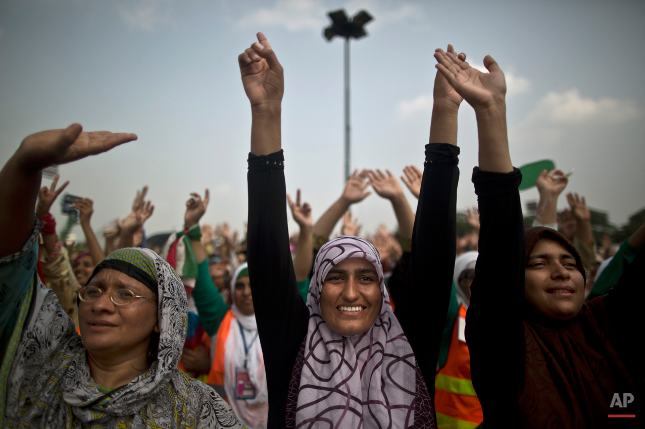 Female supporters of anti-government cleric Tahir-ul-Qadri react to his speech during a protest in front of the Parliament building, in Islamabad, Pakistan, Thursday, Aug. 21, 2014. Pakistani officials held "initial" talks before dawn Thursday with representatives from two opposition groups whose supporters have been besieging the parliament for a second day demanding the prime minister resign over alleged election fraud, the government said. (AP Photo/Muhammed Muheisen)