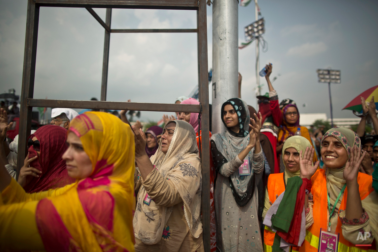 Female supporters of anti-government cleric Tahir-ul-Qadri listen to his speech, during a protest in front of the Parliament building, in Islamabad, Pakistan, Thursday, Aug. 21, 2014. Pakistani officials held "initial" talks before dawn Thursday with representatives from two opposition groups whose supporters have been besieging the parliament for a second day demanding the prime minister resign over alleged election fraud, the government said. (AP Photo/Muhammed Muheisen)