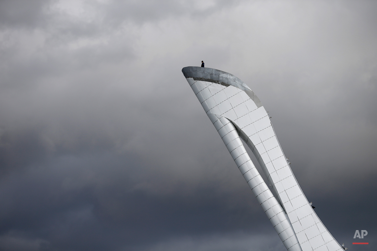  A worker is dwarfed against the sky as he stands at the top of the Olympic cauldron ahead of the 2014 Winter Olympics, Tuesday, Feb. 4, 2014, in Sochi, Russia. (AP Photo/Wong Maye-E) 