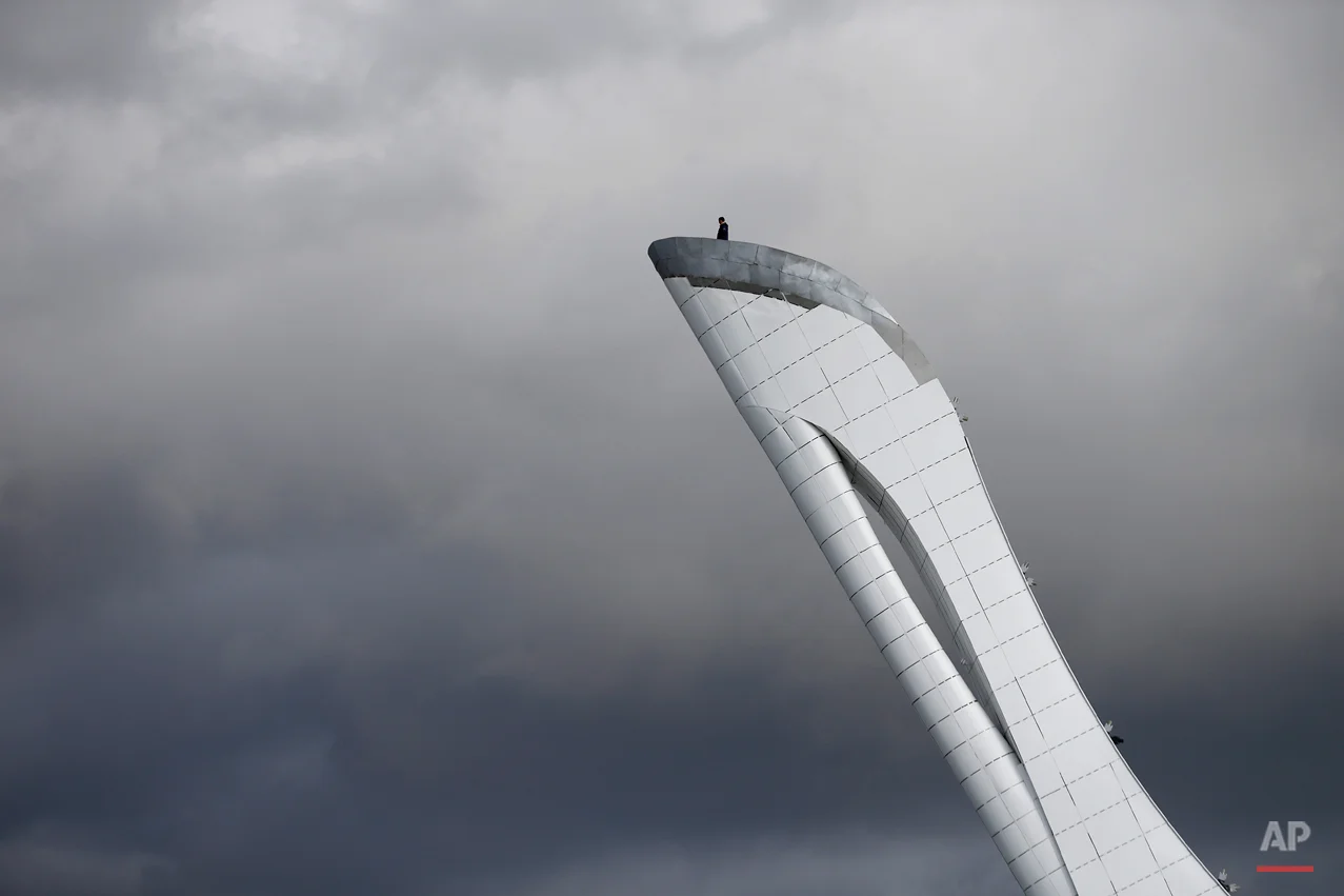 A worker is dwarfed against the sky as he stands at the top of the Olympic cauldron ahead of the 2014 Winter Olympics, Tuesday, Feb. 4, 2014, in Sochi, Russia. (AP Photo/Wong Maye-E)