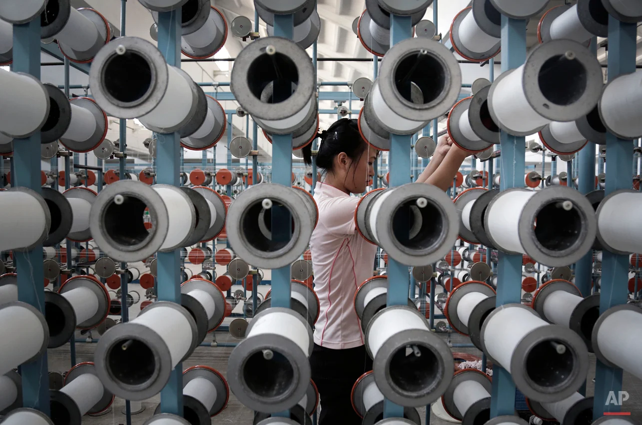 A North Korean woman works at the Kim Jong Suk Pyongyang textile factory, Thursday, July 31, 2014, in Pyongyang, North Korea. This is the country's largest textile factory with 8,500 workers, where eighty percent of them are women. (AP Photo/Wong Maye-E)