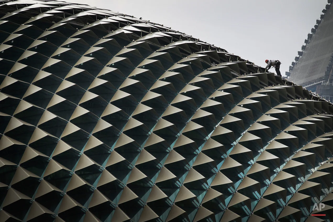 A worker perched on the roof of the Esplanade Theatre carries out the routine cleaning Wednesday, April 11, 2012 in Singapore. (AP Photo/Wong Maye-E)
