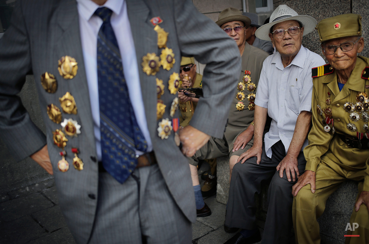  North Korean war veteran, Kim Hak Chol, 81, a retired soldier, right, together with other veterans decorated with medals, attend a parade to celebrate the anniversary of the  Korean War armistice agreement, Sunday, July 27, 2014, in Pyongyang, North