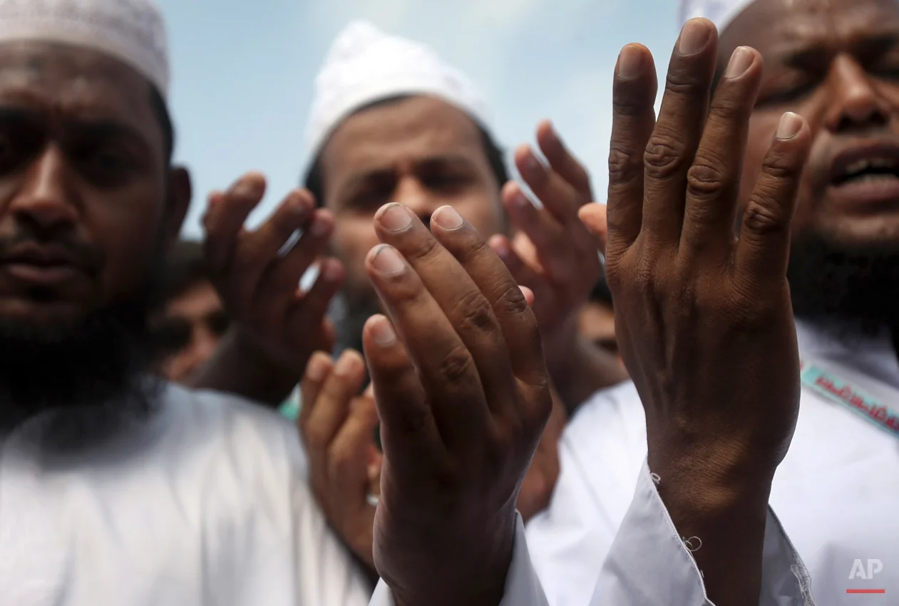 A Muslim priest leads a crowd in prayers offered to unclaimed bodies from the building that collapsed last week in preparation for a mass burial on Wednesday, May 1, 2013, in Dhaka, Bangladesh. Several hundred people attended the mass funeral in a Dhaka suburb for 18 unidentified workers who died in the building housing garment factories that collapsed last week in the country's worst industrial disaster, killing at least 402 people and injuring 2,500. (AP Photo/Wong Maye-E)