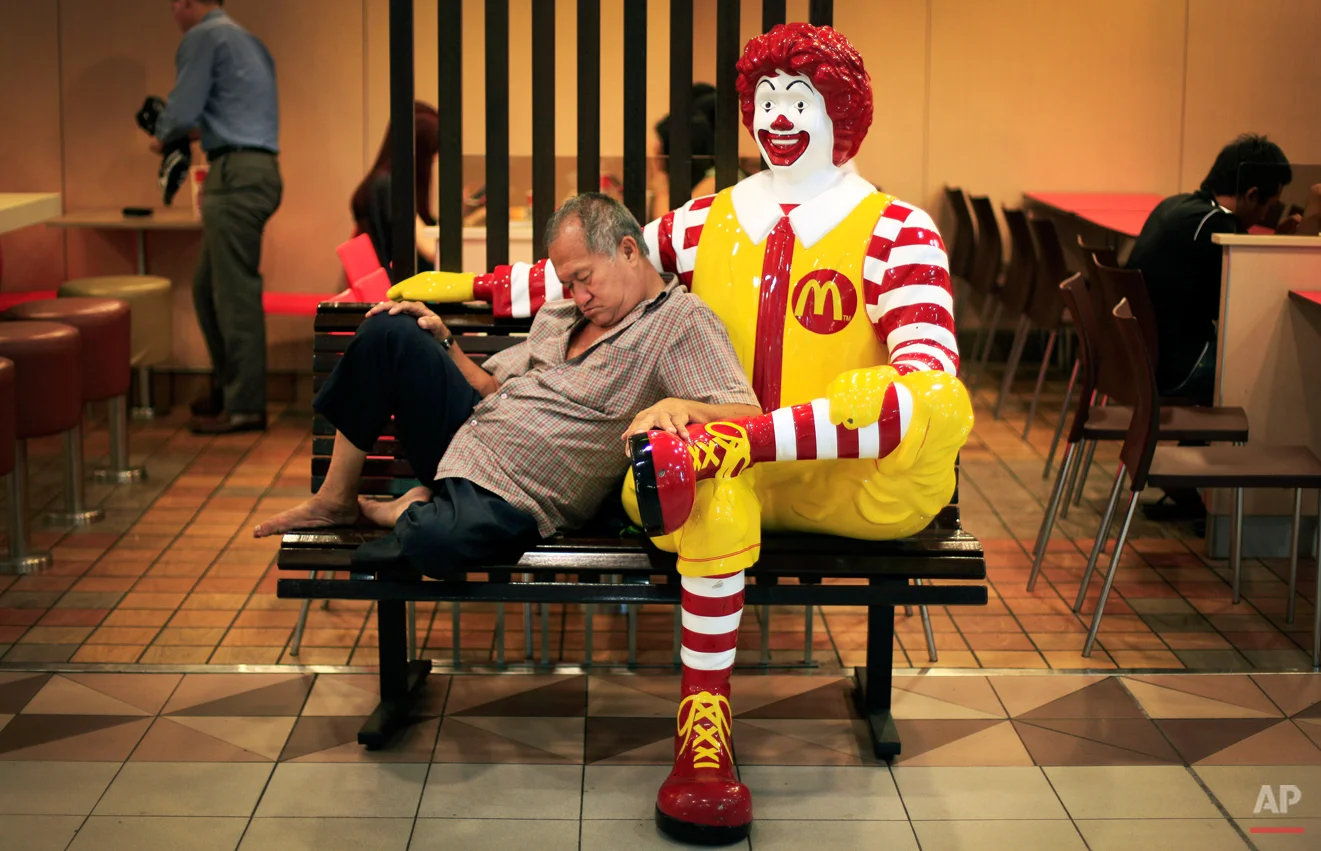 An elderly man takes his afternoon nap in a shopping mall on Friday Oct. 12, 2012 in Singapore. (AP Photo/Wong Maye-E)
