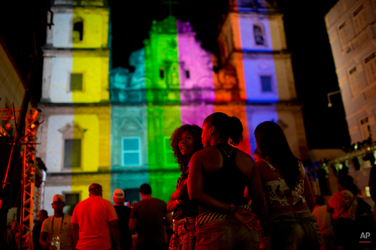  Girls gather in front of San Francisco Church, in Pelourinho neighborhood, near the Arena Fonte Nova stadium in Salvador, Brazil, where US an Belgium played a World Cup round of 16 match, Tuesday, July 1, 2014. The church is being illuminated in dif