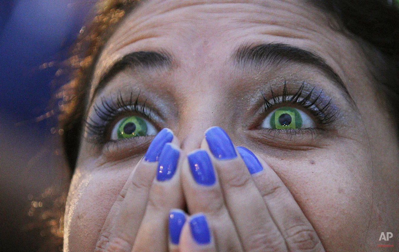  A Brazil soccer fan wearing contact lenses that mimic the Brazilian flag watches her team lose to Germany in a World Cup semifinal game via live telecast inside the FIFA Fan Fest area on Copacabana beach in Rio de Janeiro, Brazil, Tuesday, July 8, 2