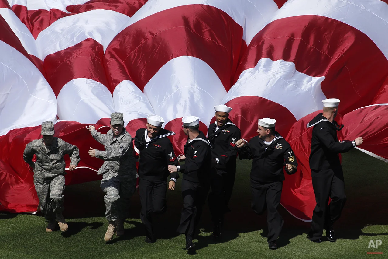 Members of the military unfurl a United States flag before Philadelphia Phillies' home opener baseball game against the Washington Nationals , Monday, April 12, 2010, in Philadelphia. (AP Photo/Matt Rourke)