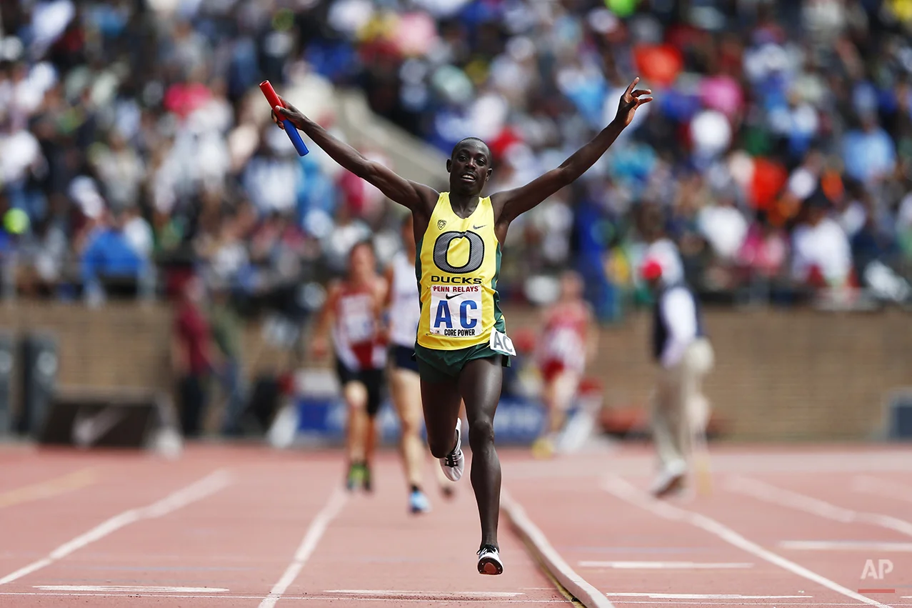 Oregon's Edward Cheserek raises his hands after crossing the finish line during the College Men's Distance Medley Championship of America at the Penn Relays athletics meet, Friday, April 25, 2014, in Philadelphia. Oregon won with a time of 9:25.40. (AP Photo/Matt Rourke)