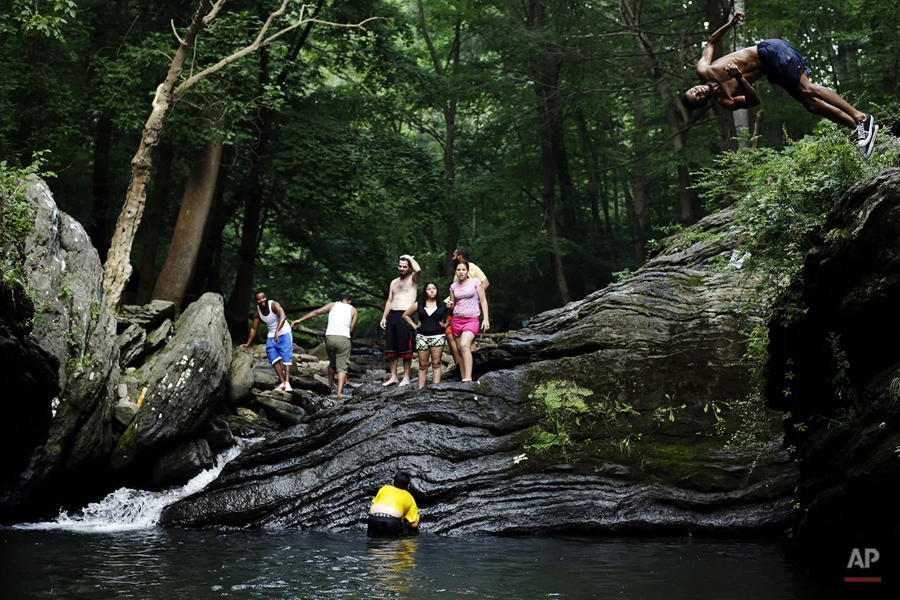 People cool off from the afternoon heat at the Devil's Pool in Wissahickon Valley Park, Friday, July 19, 2013, in Philadelphia. An excessive heat warning is again in effect for the Philadelphia region with highs expected to head up to the high-90s. (AP Photo/Matt Rourke)