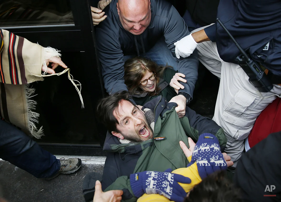 Police scuffle with protesters demonstrating in opposition to the proposed Keystone XL oil pipeline, Monday, March 10, 2014, as they block a door to the federal building in Philadelphia. The protestors say the pipeline would contribute to global warming. (AP Photo/Matt Rourke)