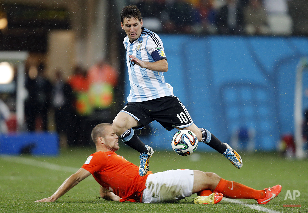  Netherlands' Ron Vlaar, bottom, tackles Argentina's Lionel Messi during the World Cup semifinal soccer match between the Netherlands and Argentina at the Itaquerao Stadium in Sao Paulo, Brazil, Wednesday, July 9, 2014. (AP Photo/Frank Augstein) 