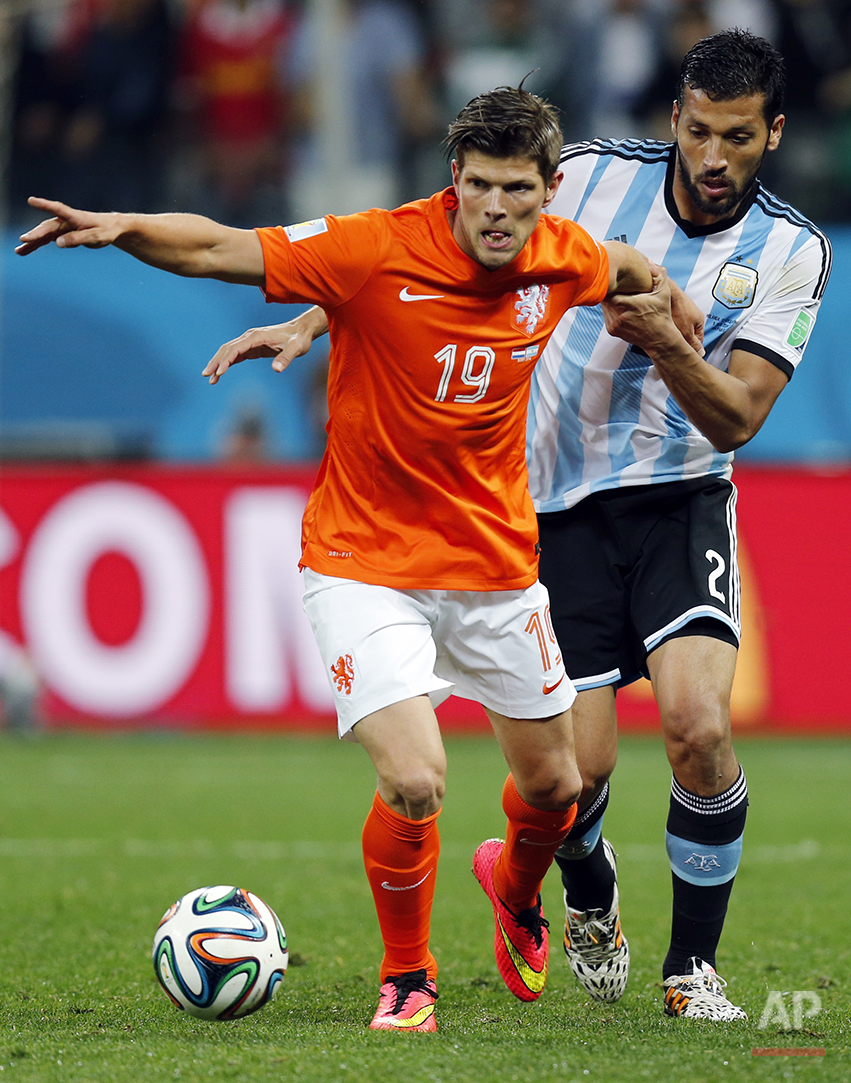  Netherlands' Klaas-Jan Huntelaar, left, is held by Argentina's Ezequiel Garay during the World Cup semifinal soccer match between the Netherlands and Argentina at the Itaquerao Stadium in Sao Paulo, Brazil, Wednesday, July 9, 2014. (AP Photo/Frank A