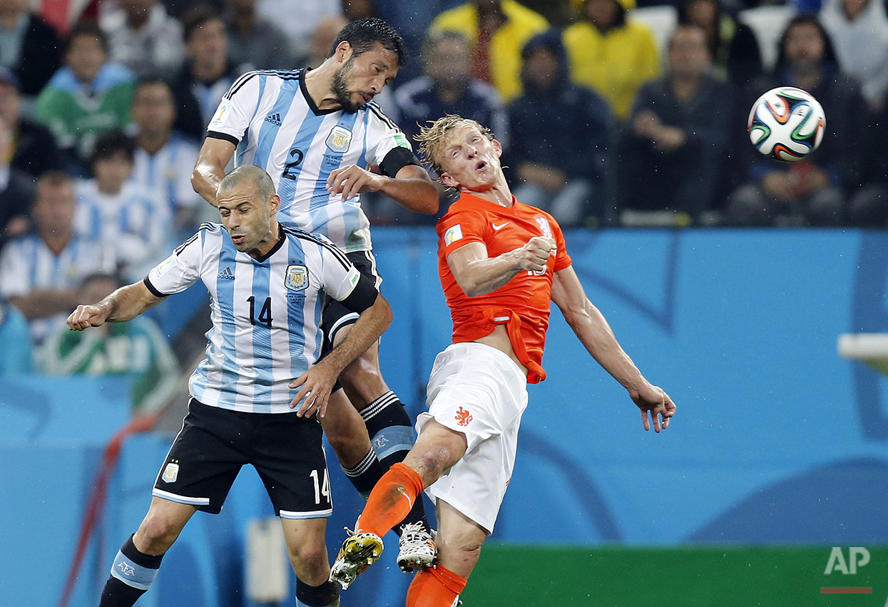  Netherlands' Dirk Kuyt, right, goes for a header with Argentina's Javier Mascherano, left, and Ezequiel Garay during the World Cup semifinal soccer match between the Netherlands and Argentina at the Itaquerao Stadium in Sao Paulo, Brazil, Wednesday,