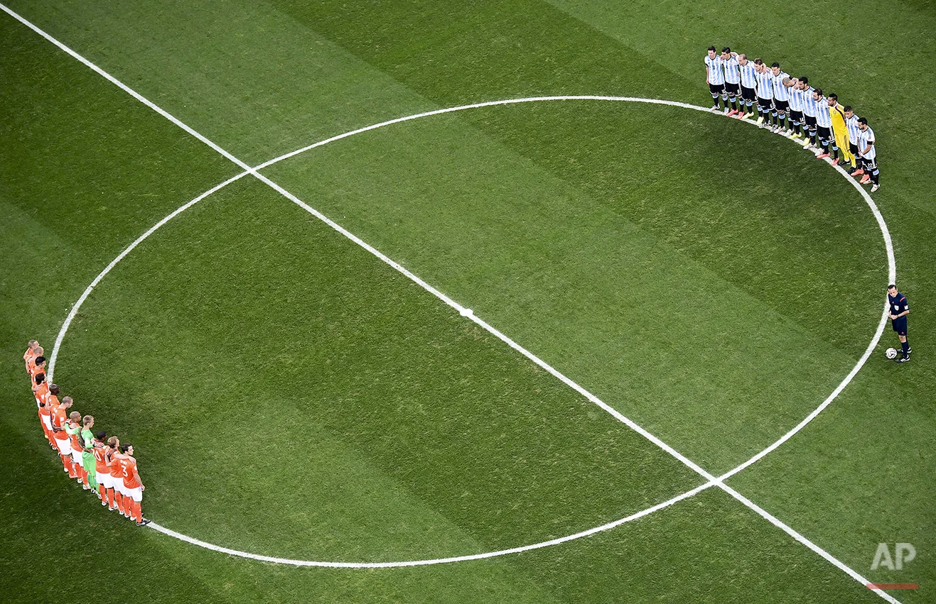 Players from the Netherlands, left, and Argentina, right, observe a minute of silence to honor the death of Argentine soccer legend Alfredo di Stefano prior to their World Cup semifinal soccer match at the Itaquerao Stadium in Sao Paulo, Brazil, Wednesday, July 9, 2014. (AP Photo/Francois Xavier Marit, Pool)