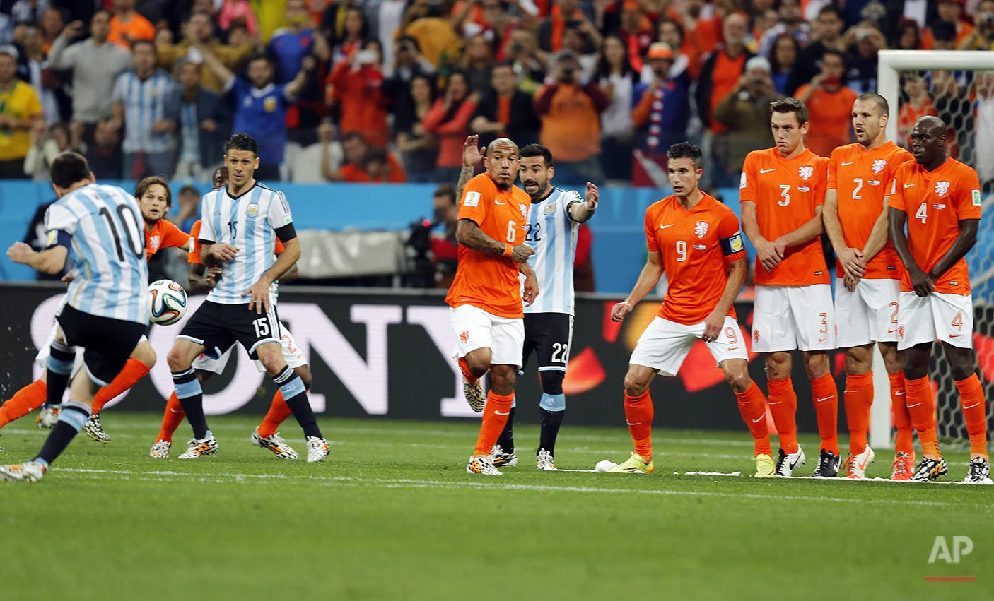 Argentina's Lionel Messi, left, shoots a free-kick past the Dutch defense during the World Cup semifinal soccer match between the Netherlands and Argentina at the Itaquerao Stadium in Sao Paulo, Brazil, Wednesday, July 9, 2014. (AP Photo/Frank Augstein)