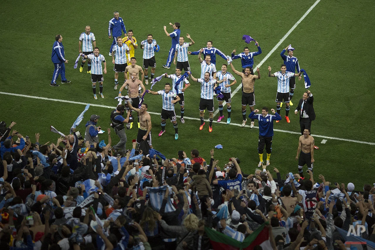 Argentina soccer players celebrate with fans after defeating the Netherlands during a World Cup semifinal soccer match at the Itaquerao Stadium in Sao Paulo Brazil, Wednesday, July 9, 2014. Argentina reached the World Cup final on Wednesday after beating the Netherlands 4-2 in a penalty shootout. (AP Photo/Felipe Dana)