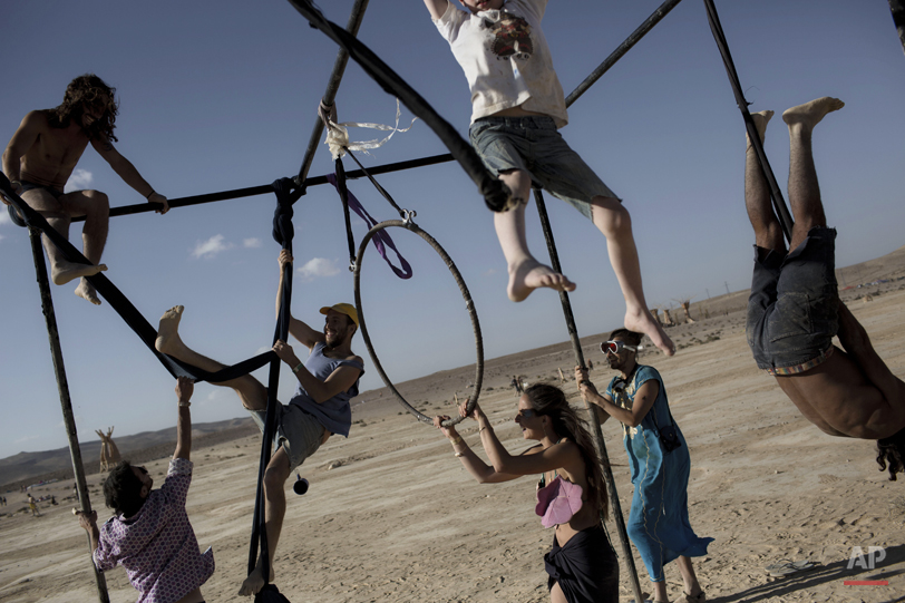  In this photo taken Friday, June 6, 2014, Israelis climb on one of the art installation during Israelís first Midburn festival, modeled after the popular Burning Man festival held annually in the Black Rock Desert of Nevada, in the desert near the I