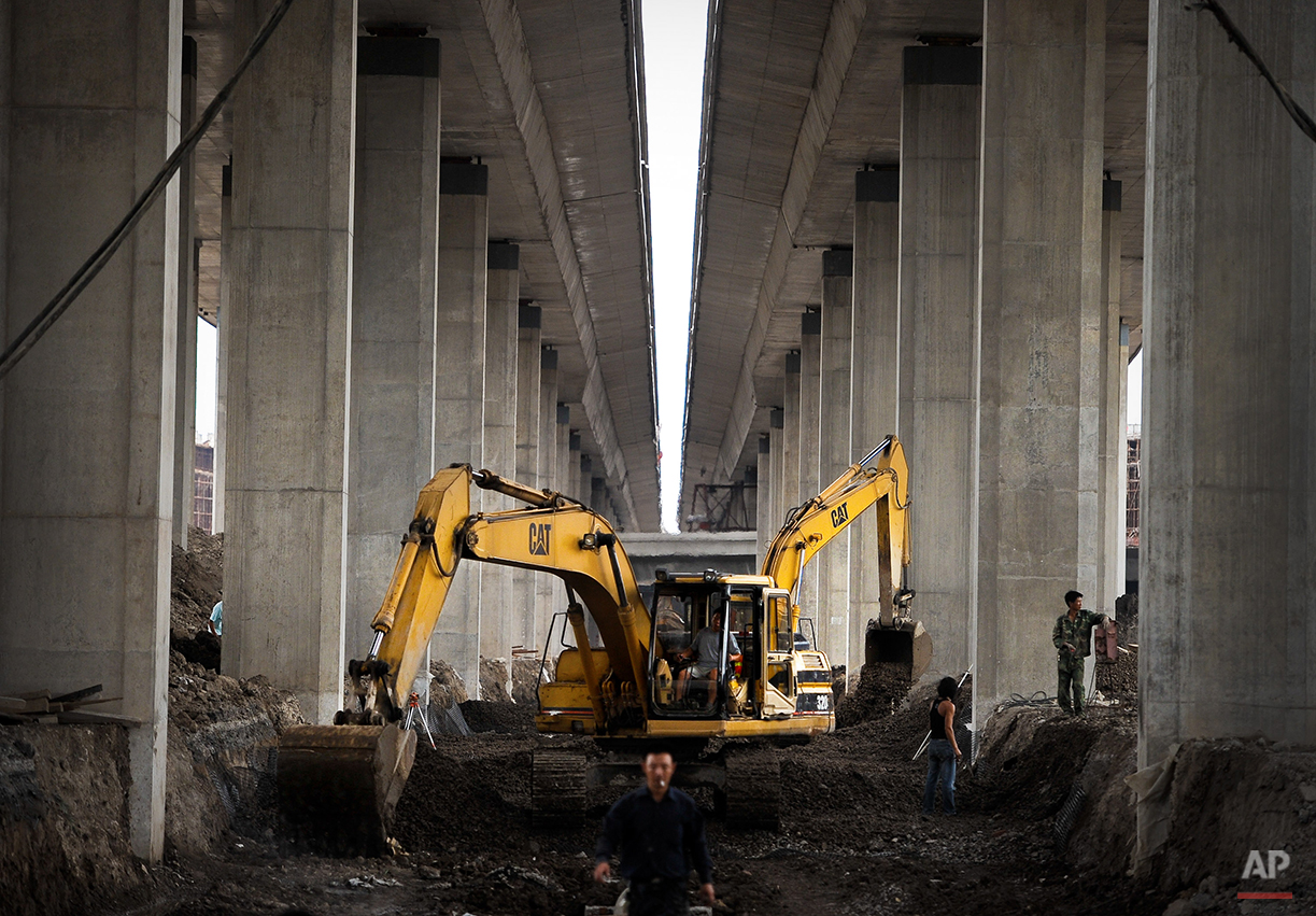  Chinese workers labor below the site of an under construction highway in Tianjin, China Thursday, Aug. 5, 2010. China is set to overtake Japan as the world's second largest-economy in a resurgence that is changing everything from the global balance 