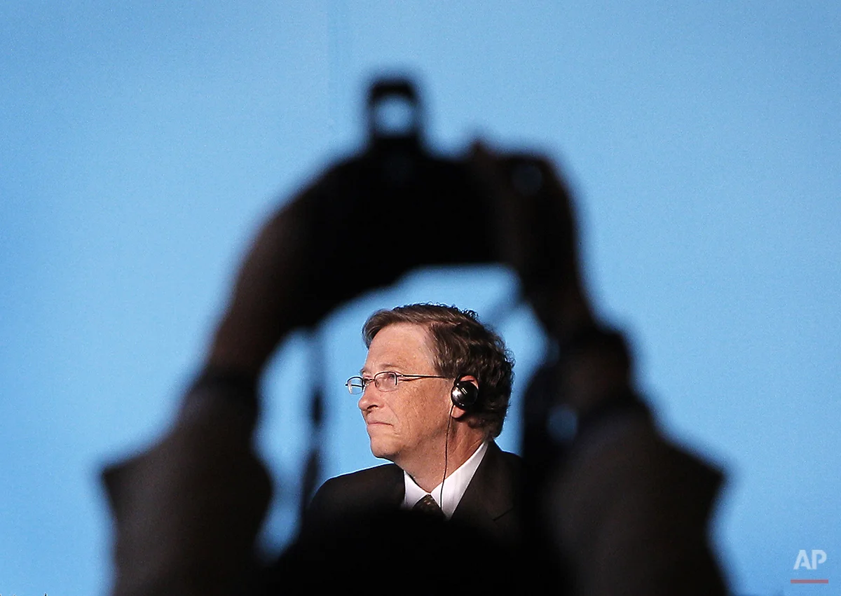 A journalist takes photos of Microsoft Corp. co-founder Bill Gates during a news conference with American billionaire Warren Buffett in Beijing, China Thursday, Sept. 30, 2010. (AP Photo/Andy Wong)