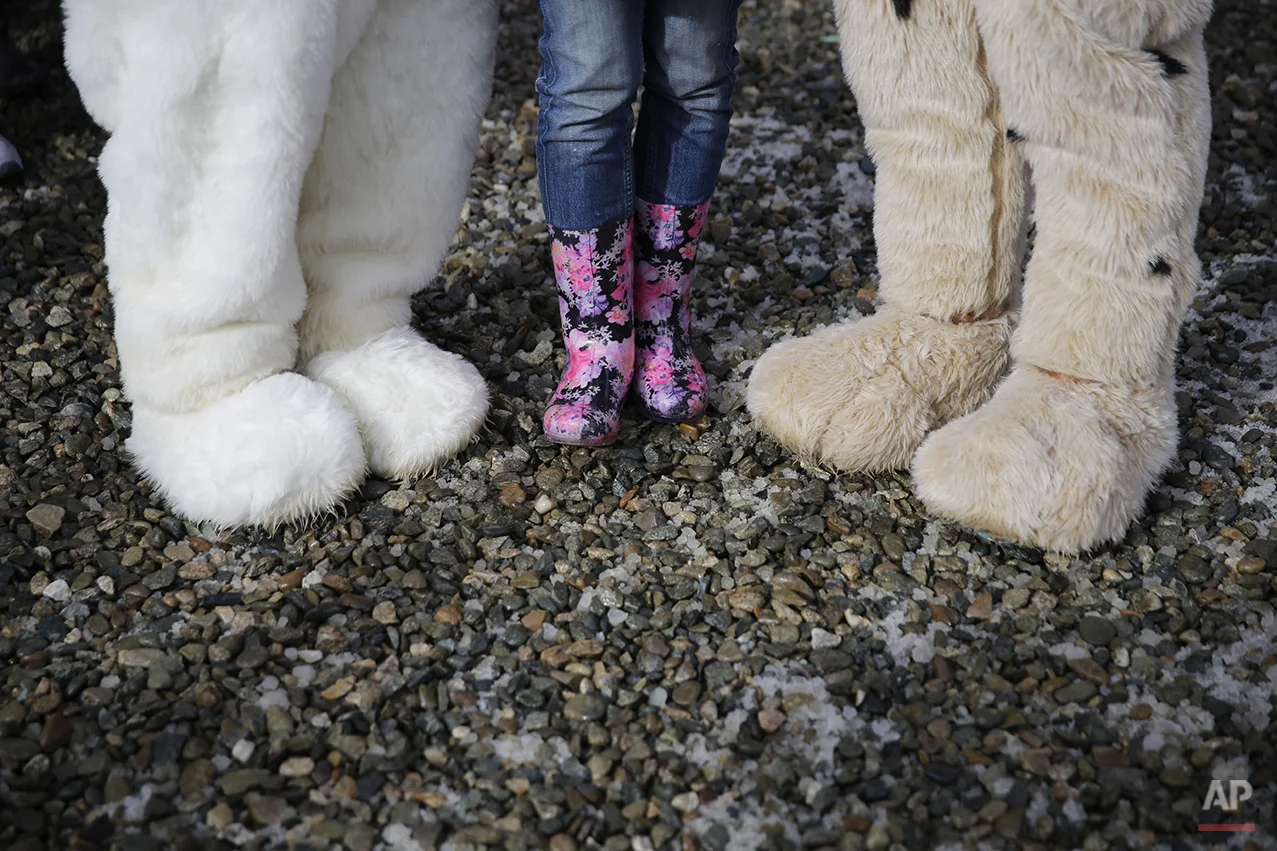 A spectator poses for photos with Sochi Winter Olympics mascots during snowboard parallel giant slalom qualifying at the Rosa Khutor Extreme Park, at the 2014 Winter Olympics, Wednesday, Feb. 19, 2014, in Krasnaya Polyana, Russia. (AP Photo/Andy Wong)