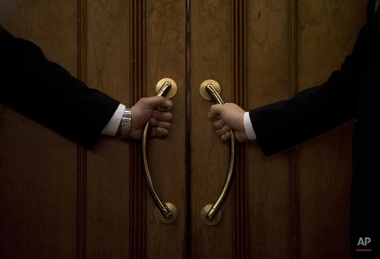 AP10ThingsToSee - Hotel security officers guard at an entrance door of a hotel room set aside for relatives or friends of passengers aboard a missing Malaysia Airlines plane, in Beijing, China Wednesday, March 12, 2014. (AP Photo/Andy Wong)