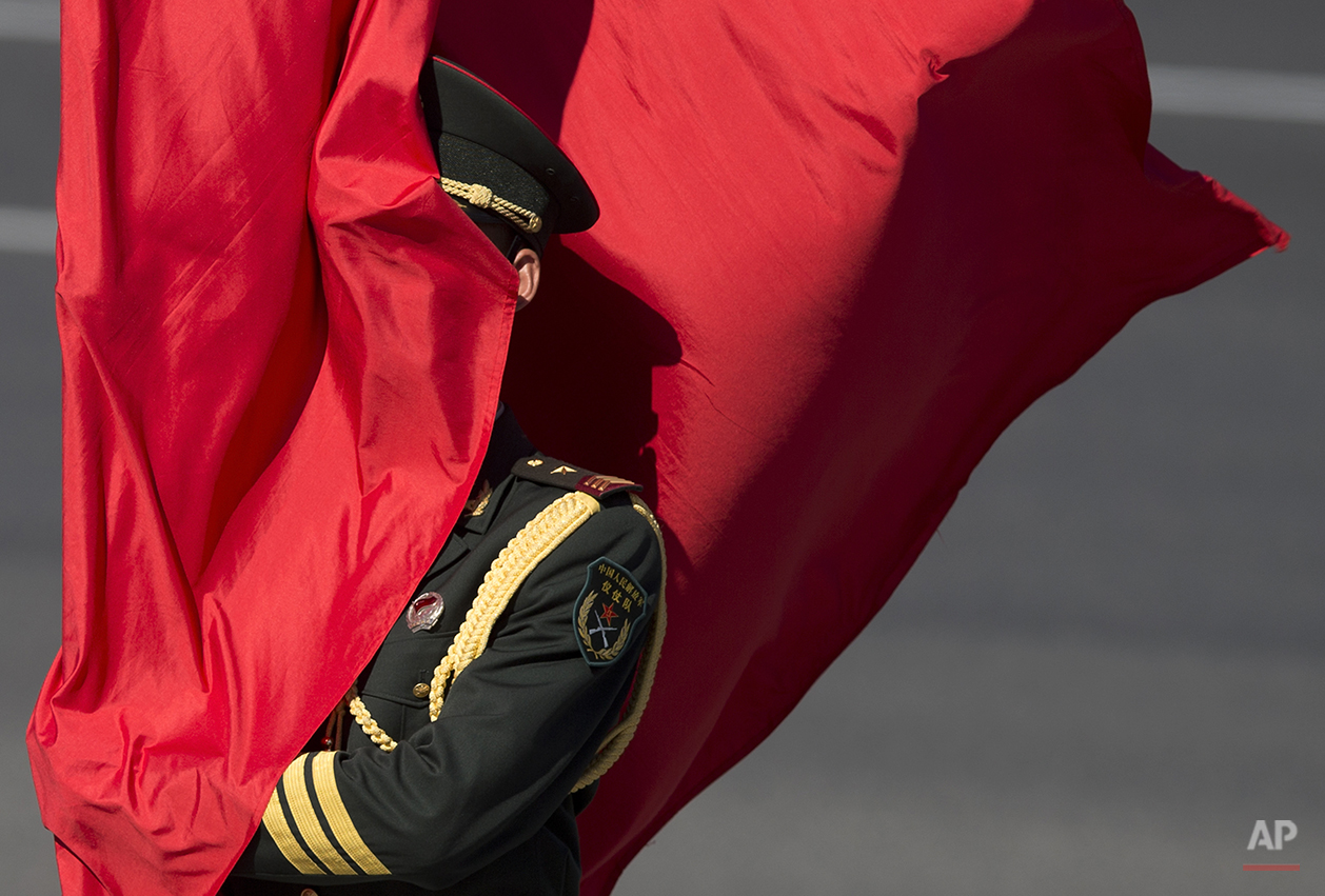  A Chinese guard of honor is covered by a red flag as he waits for the arrival of Belarus's President Alexander Lukashenko at a welcoming ceremony at the Great Hall of the People in Beijing, China Tuesday, July 16, 2013. (AP Photo/Andy Wong) 