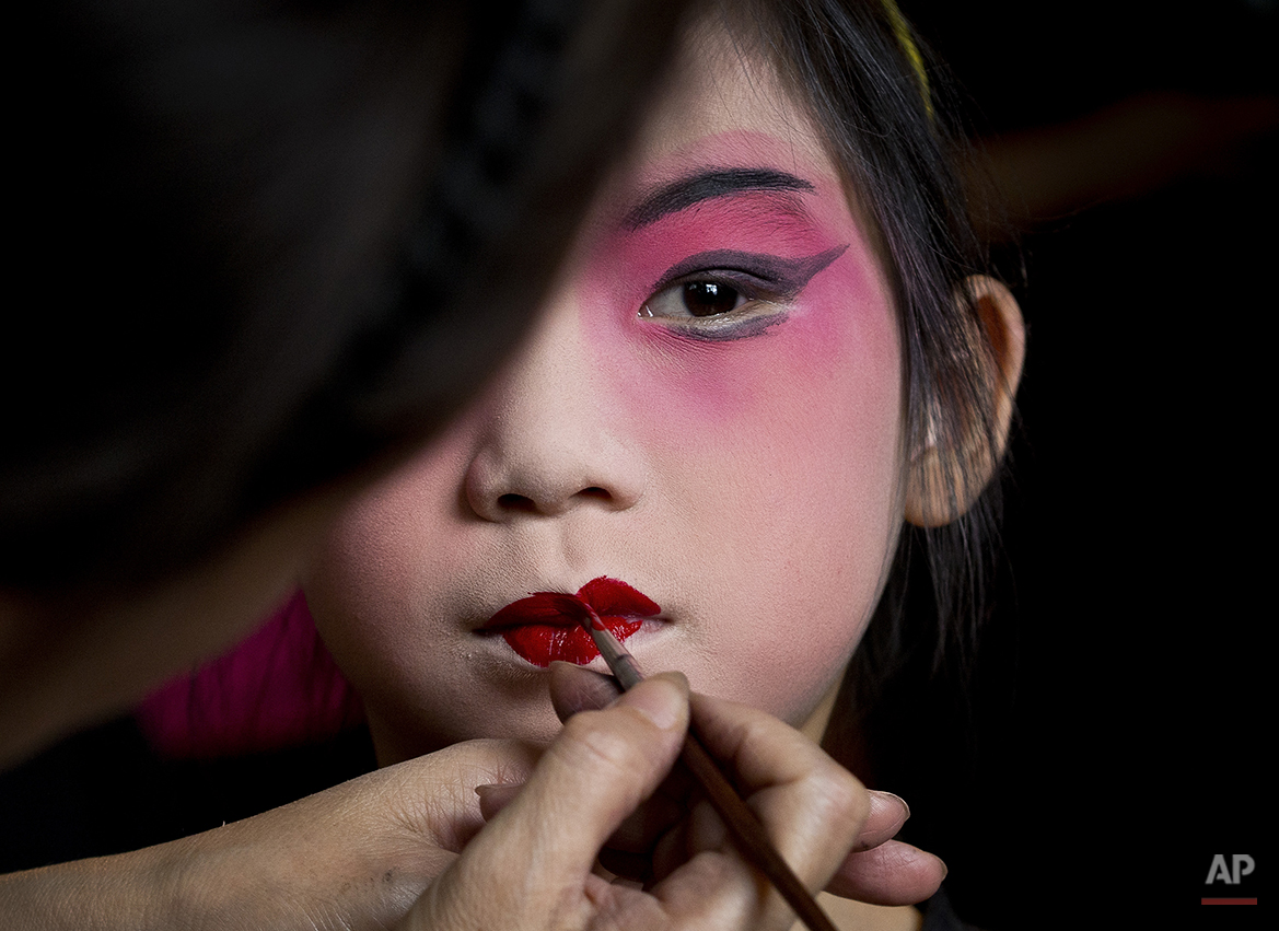  A girl is applied a makeup before a training at Peking Opera summer camp organized by the Peking Opera House in Beijing, China Tuesday, Aug. 14, 2012. The summer training course was held to attract the public to Chinese traditional performance. (AP 