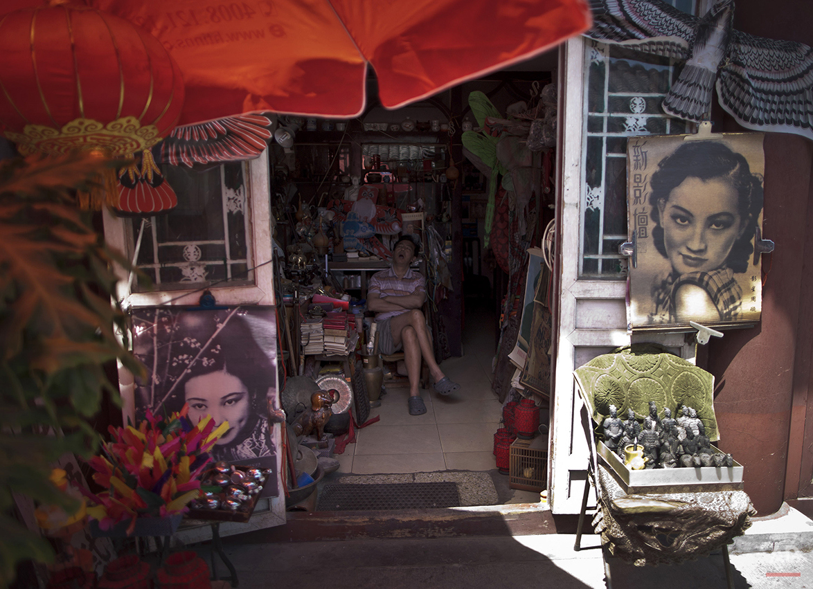  A man takes a nap as he waits for customers inside his souvenir shop at a "hutong" near Drum Tower, a tourist spot in Beijing, China Friday, June 3, 2011. (AP Photo/Andy Wong) 