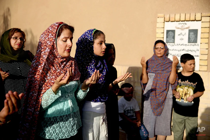 In this Saturday, June 14, 2014 photo, Zoroastrians pray in Setipir Shrine in Yazd about 405 miles (675 kilometers) southeast of the capital Tehran, Iran. Thousands of Zoroastrians, like many other Iranians, immigrated abroad under former president Mahmoud Ahmadinejad because of social restrictions and a worsening economy. But now a dozen have returned to live in Iran this past year, the government said. (AP Photo/Ebrahim Noroozi)