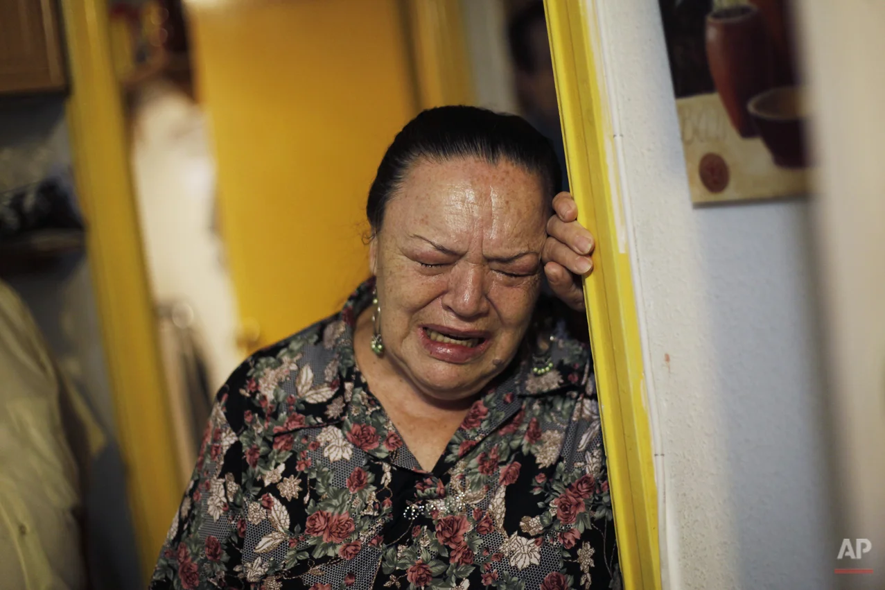 Angeles Romero Fernandez, 65-year old, right, cries as she waits to be evicted in Madrid, Spain, Tuesday July 2, 2013. Romero Fernandez, with a bipolar syndrome, and her husband 68 year-old pensioner Efren Rodriguez Gonzalez, have 6 family members unemployed and a 8 year-old grandchild and have lived together in an apartment of the City Hall Housing Company (EMVS) for 24 years. The eviction was finally postponed until September with the help of the Victims' Mortgage Platform (PAH). (AP Photo/Andres Kudacki)
