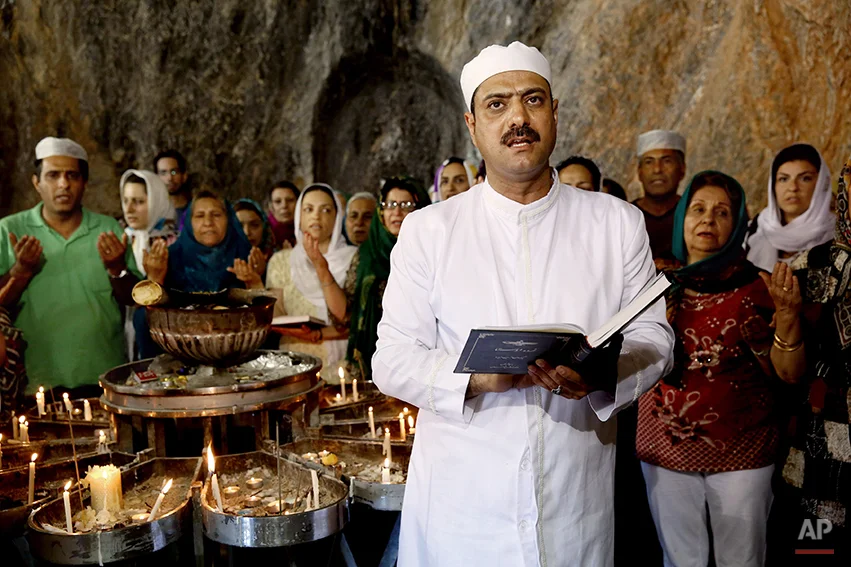 In this Friday, June 13, 2014 photo, Zoroastrian priest Kamran Lorian leads a prayer in Chak Chak, a mountain shrine, some 600 kilometers (370 miles) southeast of the capital Tehran, Iran. Adherents of the Zoroastrian religion from around the world gathered at a mountain shrine in central Iran this week to celebrate their Persian roots, praying in remembrance of a princess who fled the 7th century Arab invasion. (AP Photo/Ebrahim Noroozi)