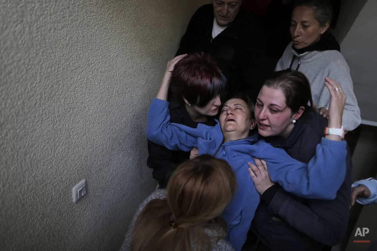 Soledad Carrasquilla Delgado, 53 year-old, center, gets help from her daughter, center right, her sister, center left, her husband, top left, and two members of the Victims' Mortgage Platform (PAH) as she faints during a panic attack following the postponement of her and her family's eviction in Madrid, Spain, Wednesday, Oct. 30, 2013. Carrasquilla Delgado and her husband Cecilio Escudero Hidalgo, live with their son Aitor,, and their daughter Noelia, in an apartment of the Madrid Housing Institute (IVIMA) for seventeen years. They are all unemployed and the family's income are state benefits of 426 euros ($586) and 564 euros ($776) per month. IVIMA offered them to buy the property but they could not afford it. The eviction was finally postponed with the help of the Victims' Mortgage Platform (PAH). (AP Photo/Andres Kudacki)