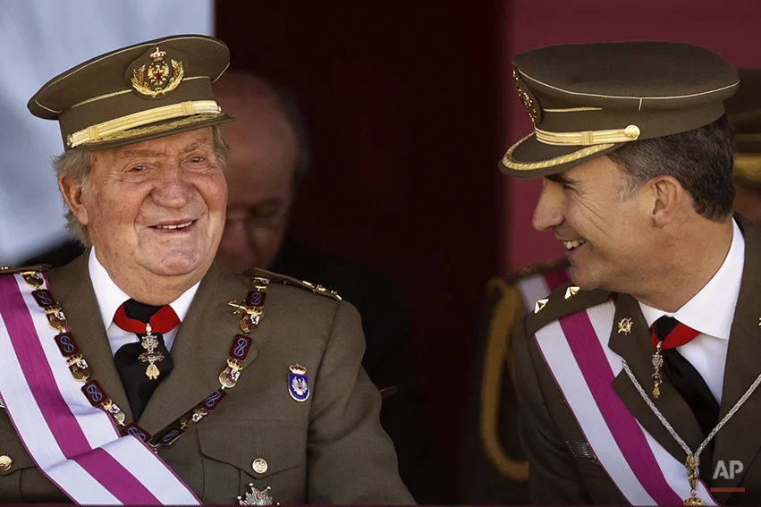 King Juan Carlos and Crown Prince Felipe, right, attend a military ceremony in San Lorenzo de El Escorial, outside Madrid, Spain, Tuesday, June 3, 2014. Spanish Prime Minister Mariano Rajoy is holding an emergency cabinet meeting to draft the legal process for King Juan Carlos to abdicate and be replaced by his son, Crown Prince Felipe. The handover cannot happen until the government crafts the mechanism for abdication and Felipe's assumption of power. The proposal is expected to pass quickly because Rajoy's center-right Popular Party has an absolute majority in Parliament.(AP Photo/Daniel Ochoa de Olza)