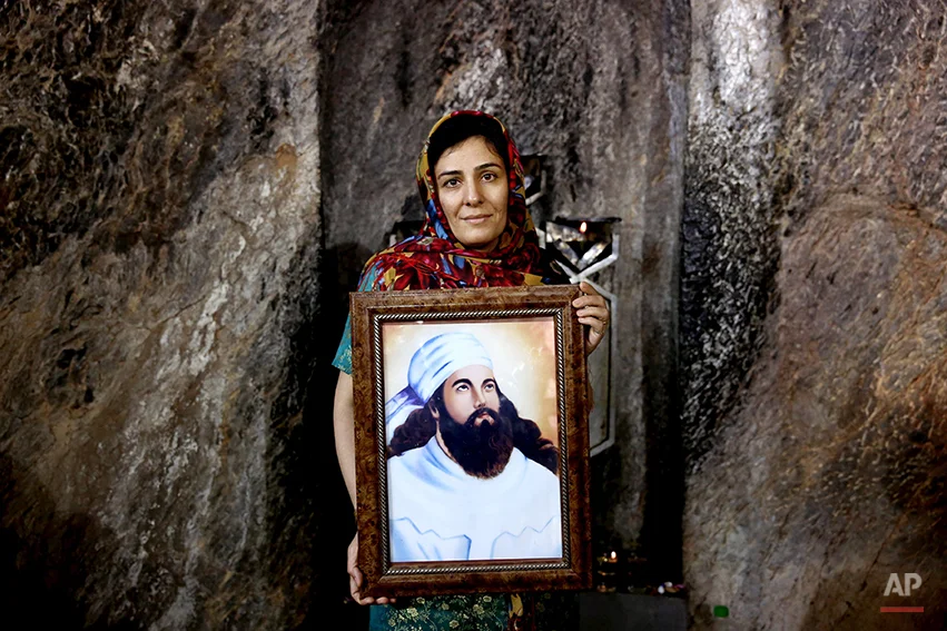In this Friday, June 13, 2014 photo, a Zoroastrian woman holds a portrait of prophet Zoroaster in Chak Chak, a mountain shrine, some 600 kilometers (370 miles) southeast of the capital Tehran, Iran. Zoroastrianism is a monotheistic religion predating Christianity, Islam and Judaism, founded some 3,800 years ago by the prophet Zoroaster. It was the dominant religion in Persia before the Arab conquest. (AP Photo/Ebrahim Noroozi)