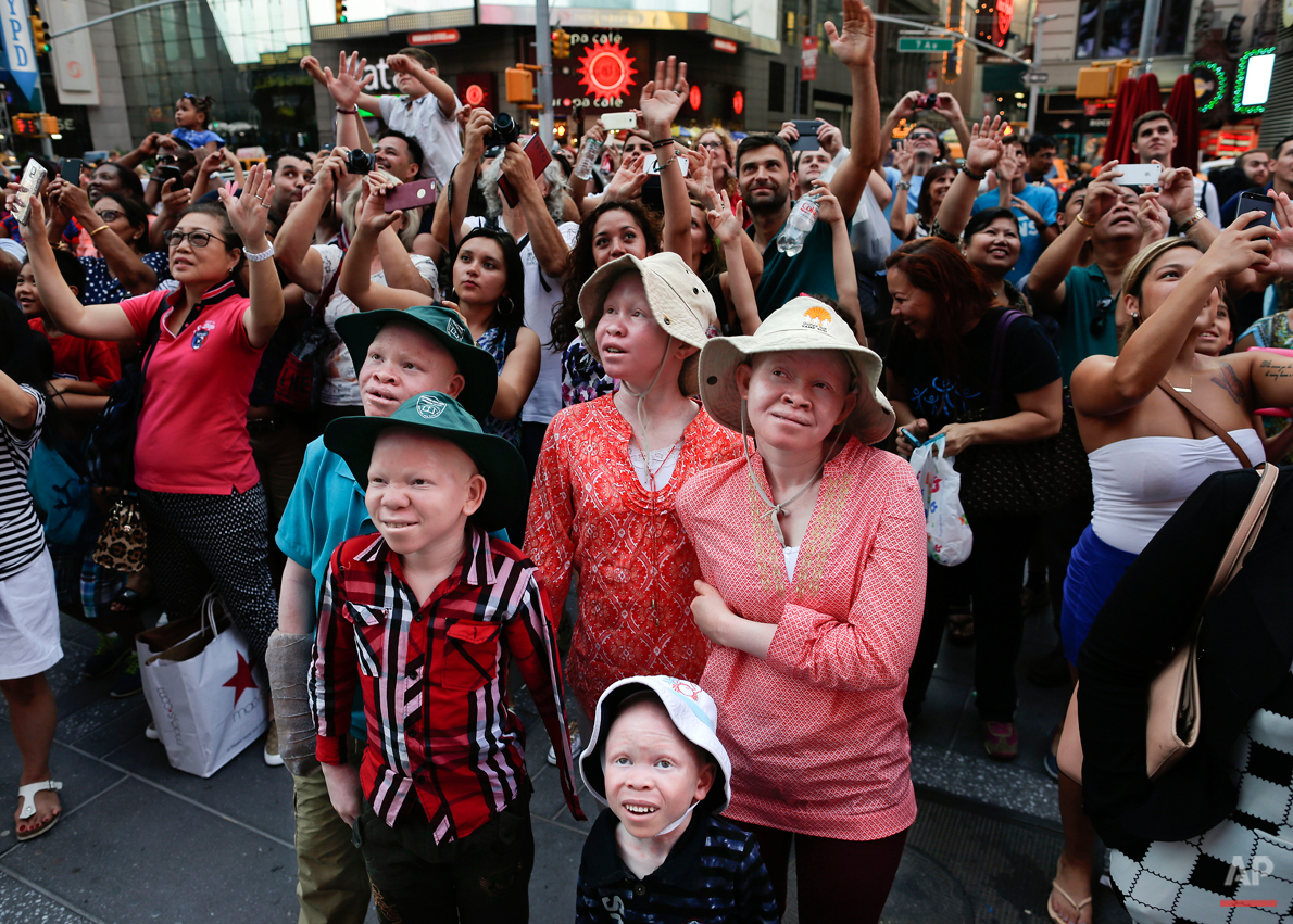  Emmanuel Rutema, Kabula Masanja, Pendo Noni, Mwigulu Magesa and Baraka Lusambo watch the Revlon live camera with a crowd of other tourists during a visit to Times Square in New York on Tuesday, July 28, 2015. People with the genetic condition of alb