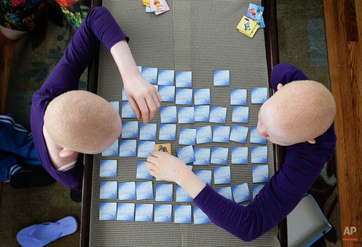 Pendo Noni, left, and Kabula Masanja play a memory card game in New York on Tuesday, July 28, 2015. One out of every 1,400 citizens in Tanzania has albinism. Pendo and Kabula were attacked and dismembered in the belief that their body parts will bri