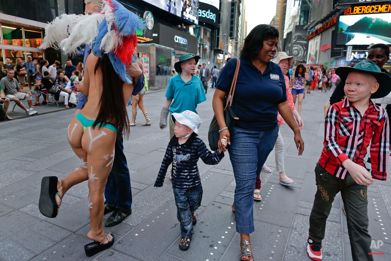  Monica Watson holds Baraka Lusambo's hand as they walk through Times Square with Emmanuel Rutema, background left, Kabula Masanja, obscured behind Watson, Pendo Noni, background right, and Mwigulu Magesa, right, in New York on Tuesday, July 28, 2015