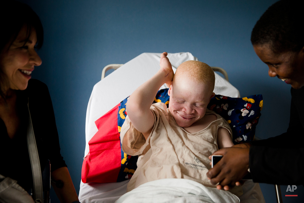  Emmanuel Rutema, 13, of Tanzania laughs with Elissa Montanti, left, founder and director of the Global Medical Relief Fund, and interpreter Ester Rwela ahead of his surgery at the Shriners Hospital for Children in Philadelphia on Tuesday, June 30, 2