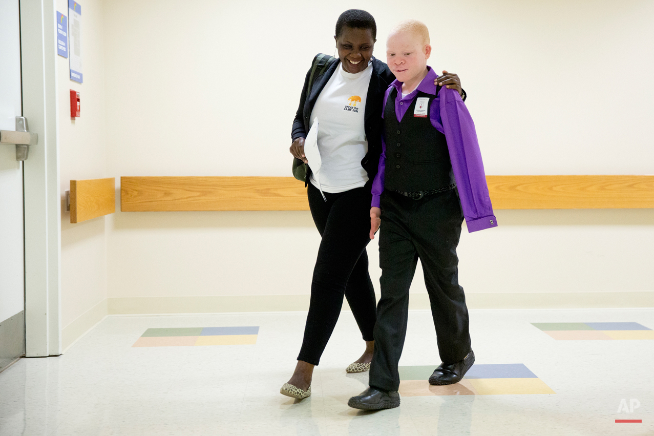  Emmanuel Rutema, 13, of Tanzania, walks with interpreter Ester Rwela before his surgery at the Shriners Hospital for Children in Philadelphia on Tuesday, June 30, 2015. Rutema and four other children also with albinism are in the U.S. to receive fre